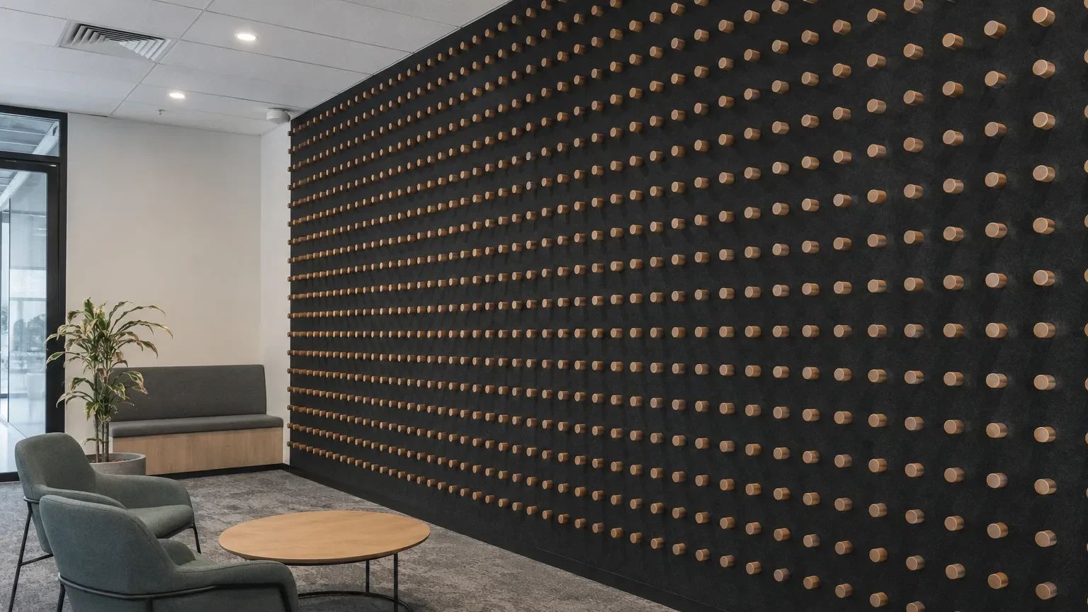 AUS Dowels timber dowel acoustic panels forming a full-height feature wall on charcoal acoustic backing in a commercial office lounge — Acoustic Panels Australia