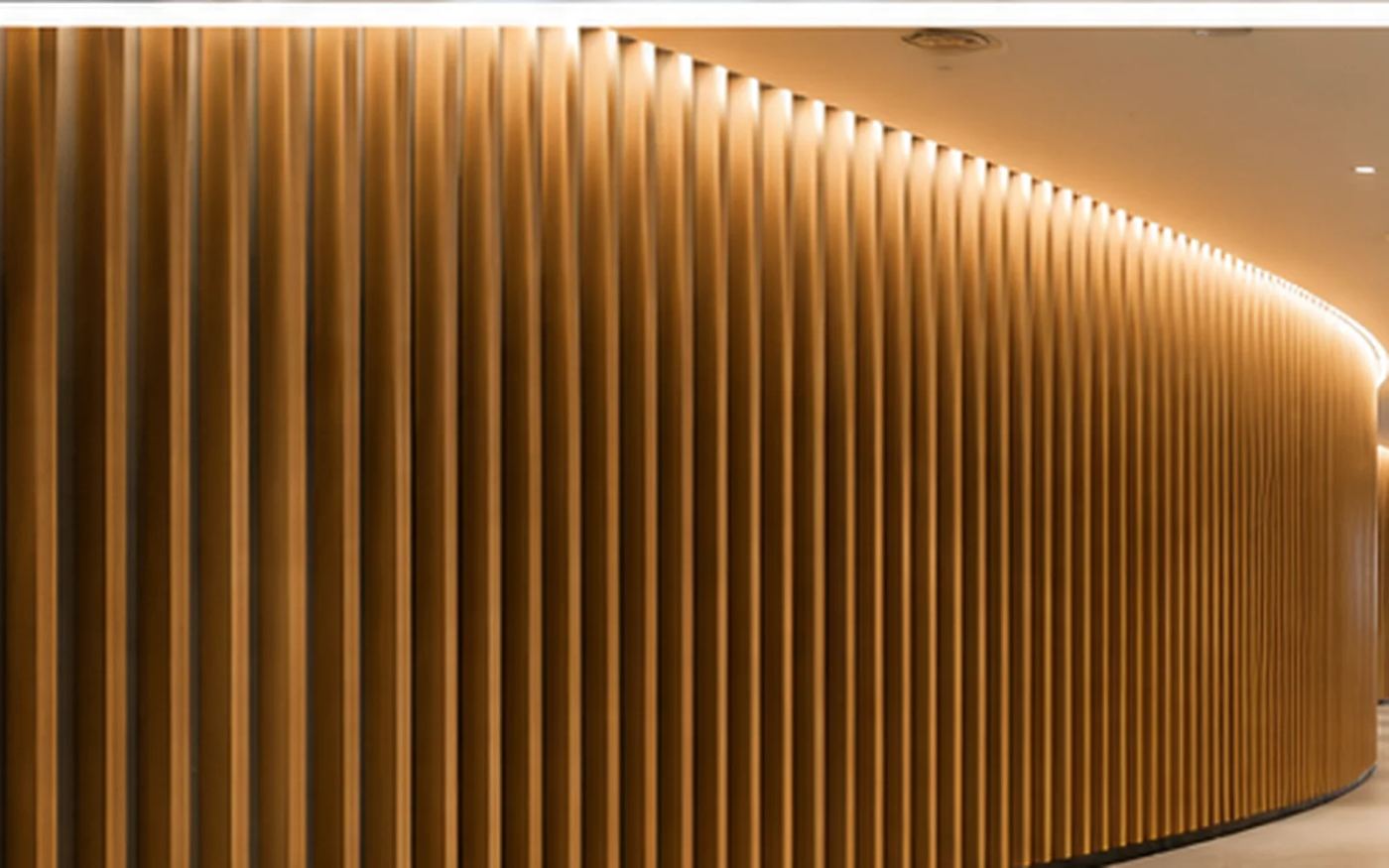 A curved timber slat acoustic feature wall with concealed cove lighting in an airport terminal concourse — Acoustic Panels Australia