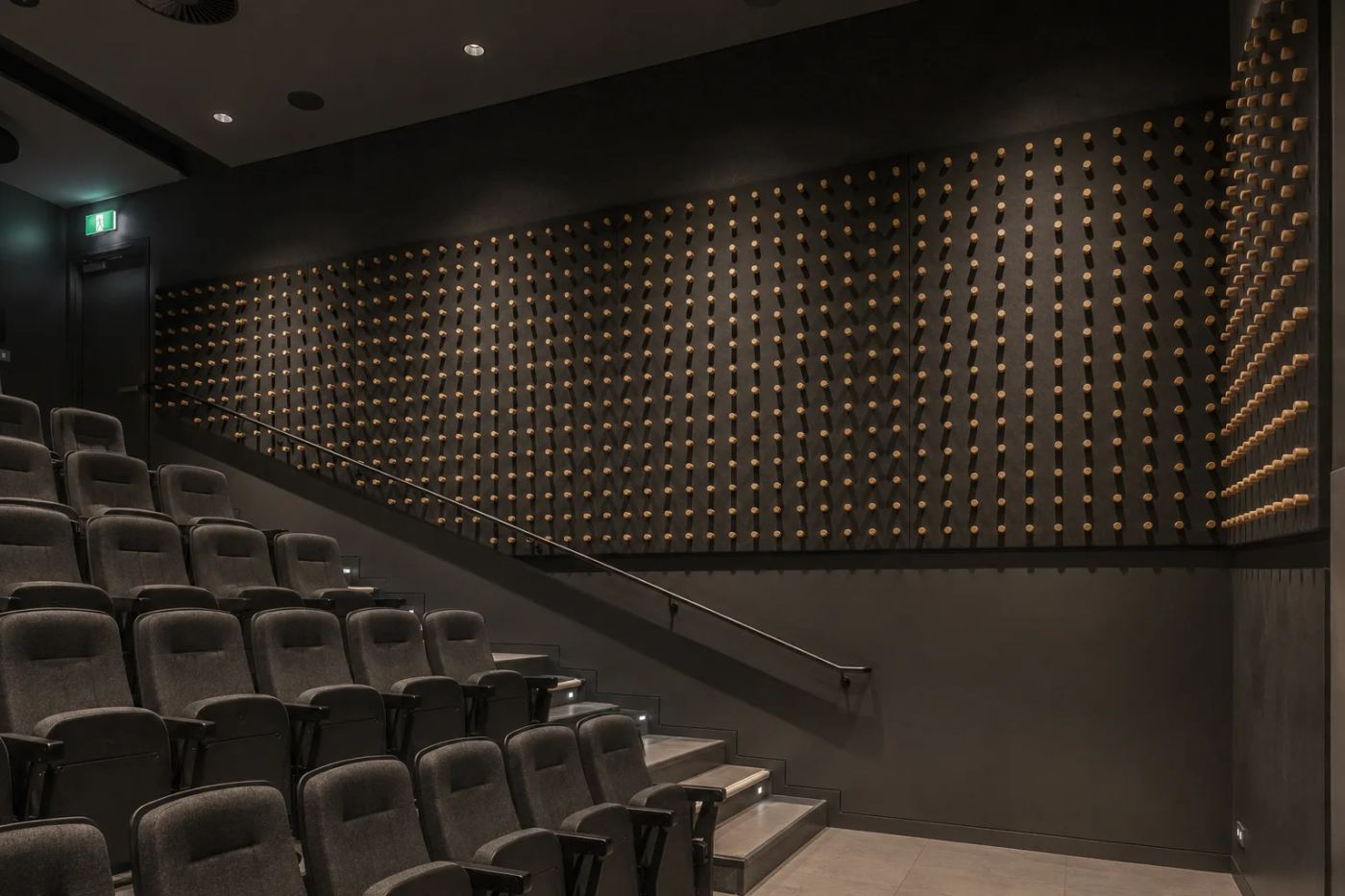 AUS Dowels timber dowel acoustic panels lining an auditorium wall, with raking light casting shadows across the projecting dowels to form a sculptural three-dimensional surface — Acoustic Panels Australia